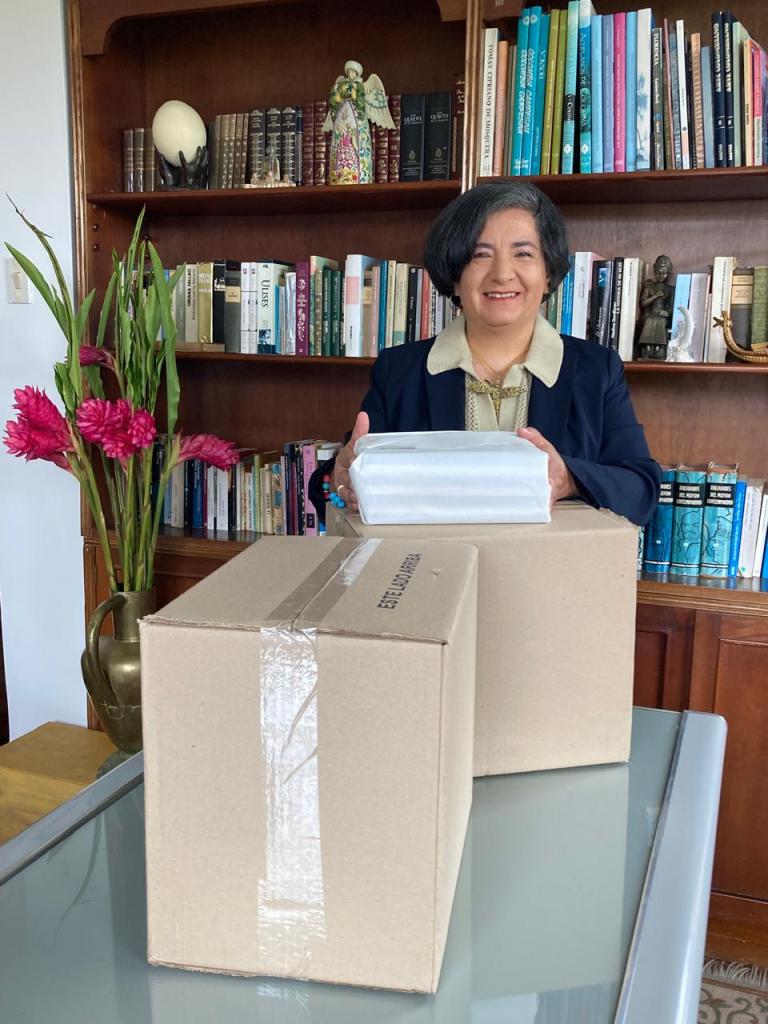 Lorena junto a las cajas cerradas, sonriendo